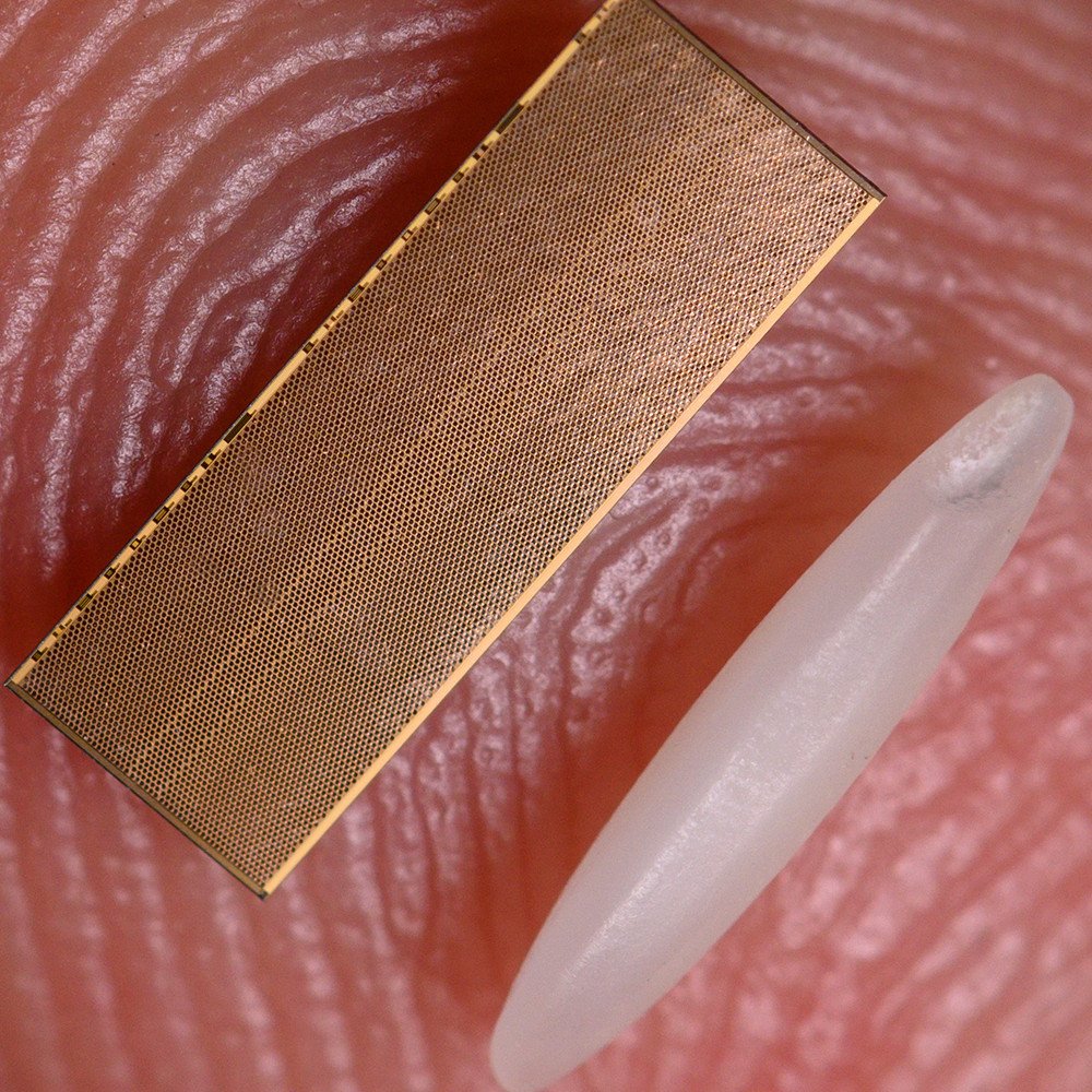 A piece of EMIB silicon next to a grain of rice
