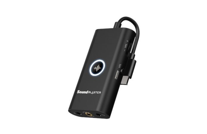 The Creative Sound Blaster G3, a slim palm-sized dongle that's rounded on the long sides with a short USB-C cable coming out of one end, audio ports on the other, and control wheels and switches on the sides. There's also a button pressed into the centre of the dongle.