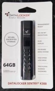 Datalocker sentry k300 in packaging, from the front. Features declared are "secure, encrypted storage", "management ready", "aes 256 bit encryption", "oled display", "on-board menu system", "high-speed uSSD drive" and "true alpha-numeric password".